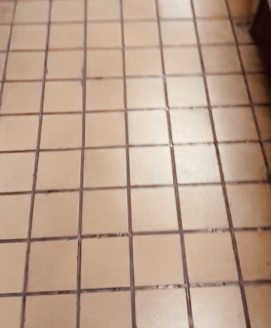 Installed tan tile floor with dark grout lines